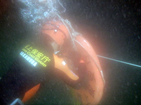 潜水訓練中浮き輪をくぐる潜水士